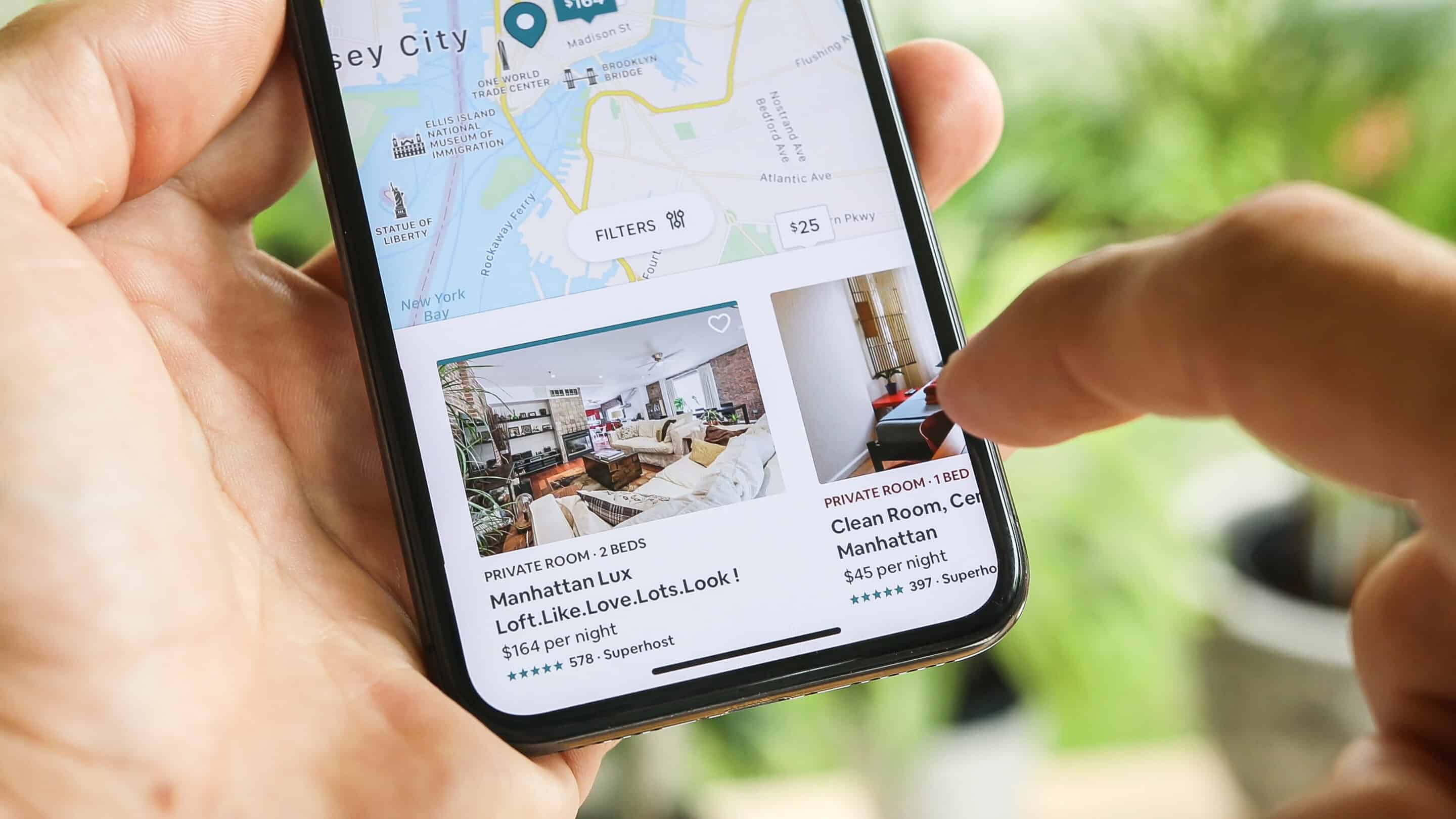 close-up image of person pointing on map-pack on mobile device, outside/greenery background
