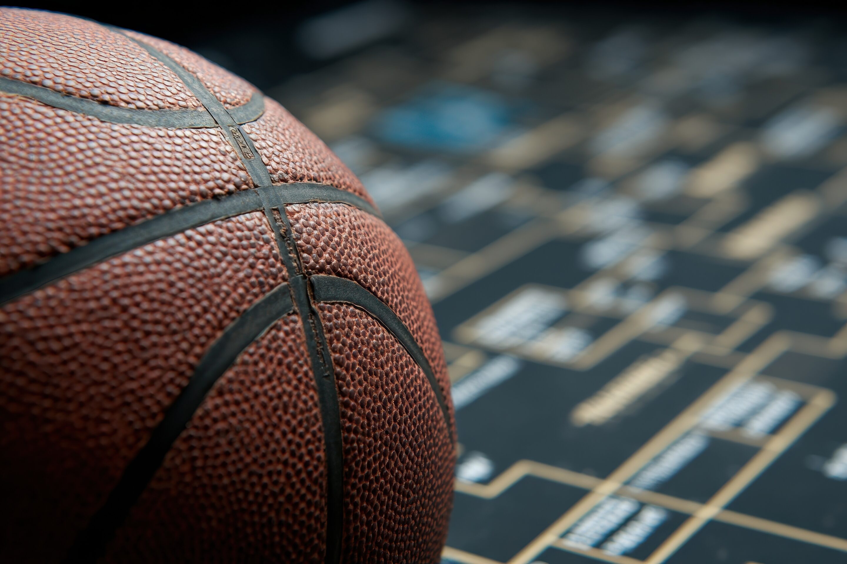 basketball resting on top of a march madness bracket